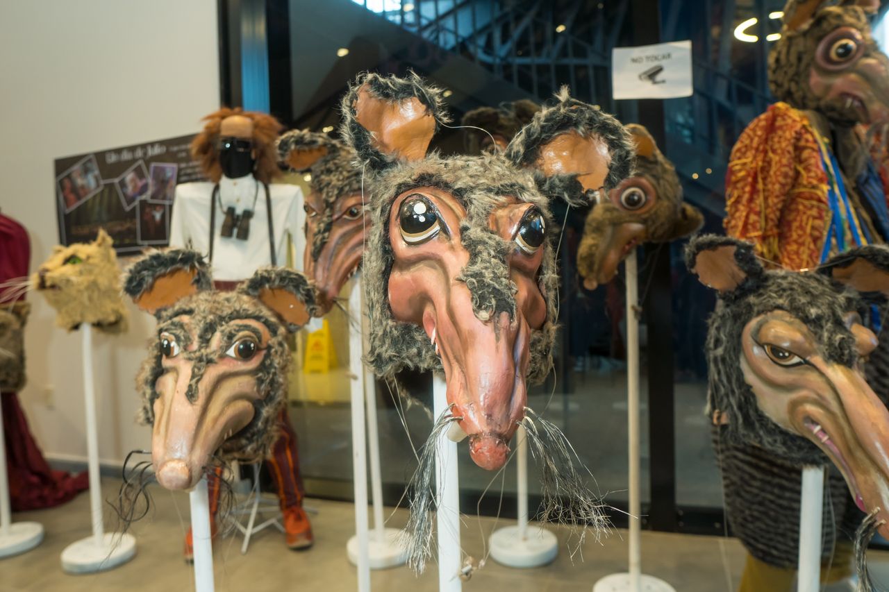 Carnaval Uruguayo — cabezas de personajes sobre pedestales, contra el vidrio.