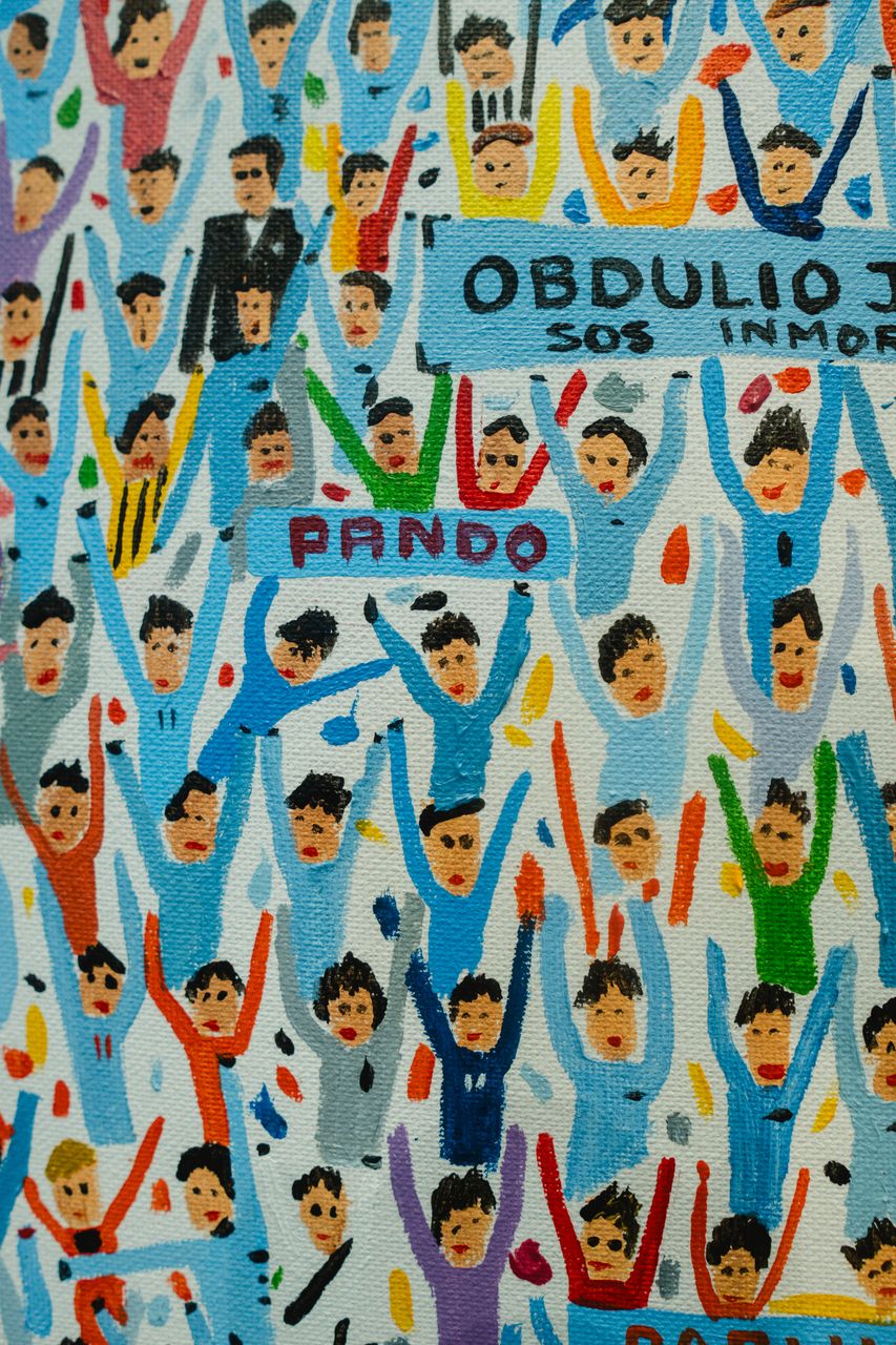 Gol en 3 colores — detalle de la multitud: el cartel de Pando.