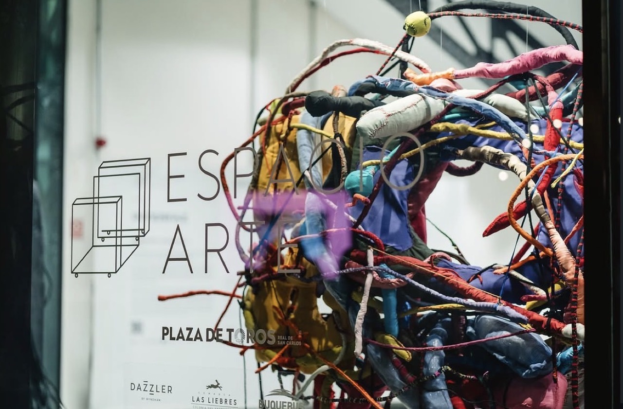 Interfaz — escultura de cables frente al cartel de espacio arte.